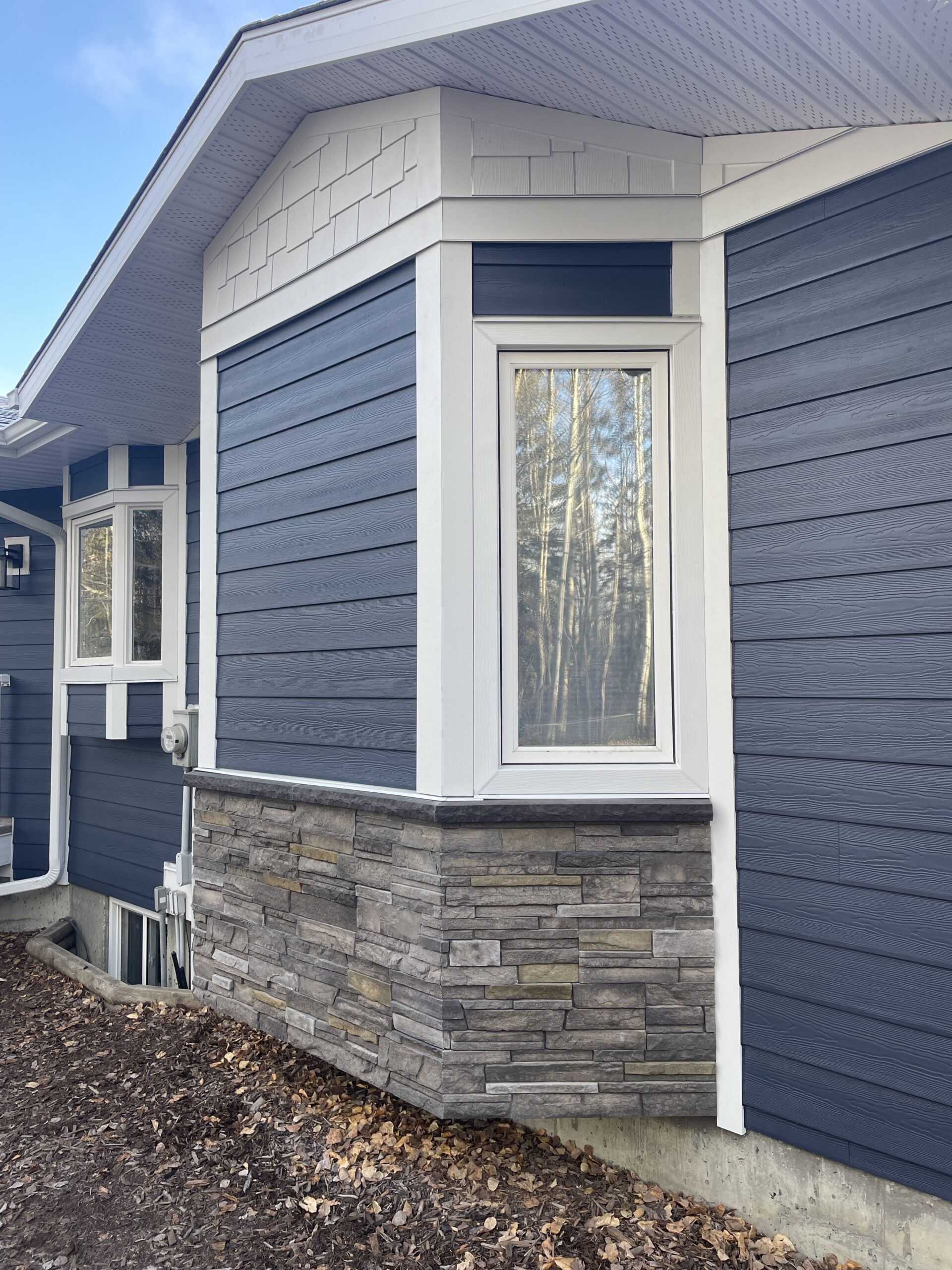 Sterling Versetta Stone with Deep Ocean Blue Hardie Plank Siding in Parkland County