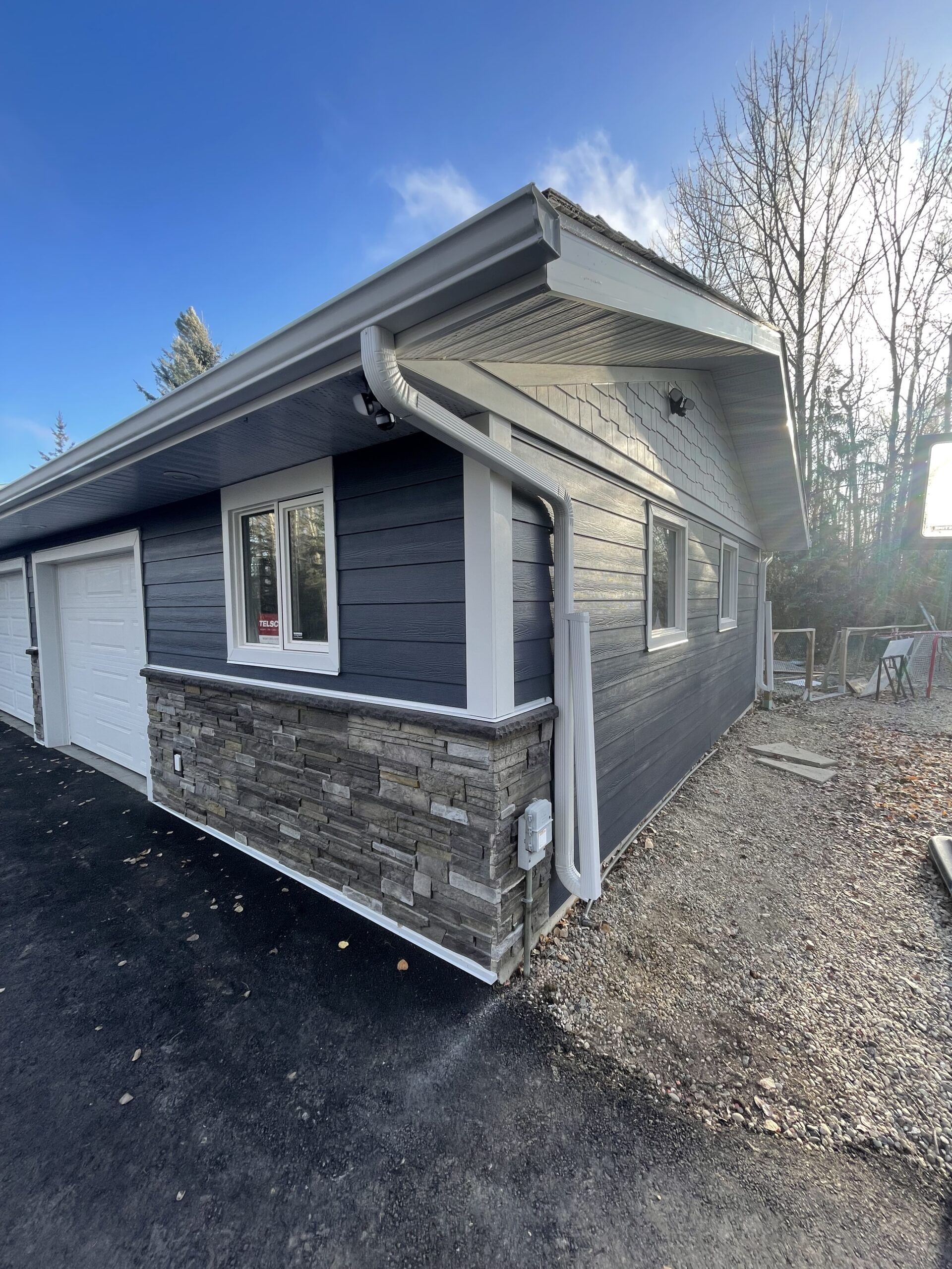 Sterling Versetta Stone with Deep Ocean Blue Hardie Plank Siding in Parkland County